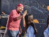 A Graffiti Park Las Vegas artist "high fives" a young Downtown Boys & Girls Club member during the painting of the mural on one of the exterior Club walls.