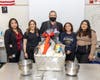 Pictured during the presentation are: (from left):  Kristina Ballesteros, Fisher’s wife; Maggie Kolesar, Move 4 Less general sales manager; Chad Fisher, Western High School culinary arts teacher; and students Leslie Cabrera and Alexis De La Cruz.