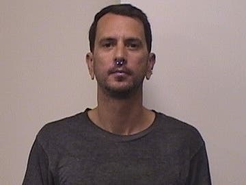 Greg McGuiness, 37, of 10 Indian Hill Road in Redding, was arrested on a warrant after posting photos holding an AK-47 assault rifle.