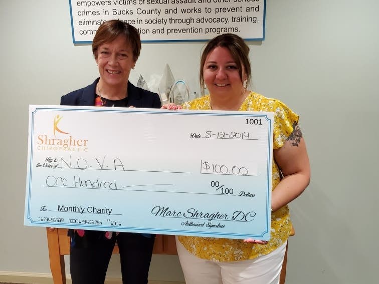 (L to R) Penny Ettinger, Executive Director, NOVA and Angela M. McGettigan, Director of Community Relations and Development, NOVA accept a check from Shragher Chiropractic Center.