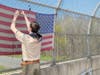 Owen Maslanka removes a worn flag along Rt. 78