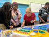 Cathleen Newsham of Modern Mosaic Arts assists Boys & Girls Club teens with adding pieces to the mural.