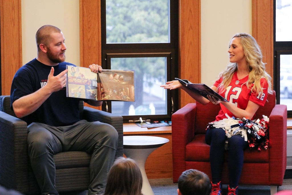 New Patriots offensive lineman Joe Thuney and cheerleader Andrea Cadigan read to kids at the Boyden Library.