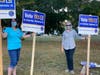 Lisa Fiske Heger and Kathy Tuffy hold signs in support of the debt exclusion for Braintree schools.