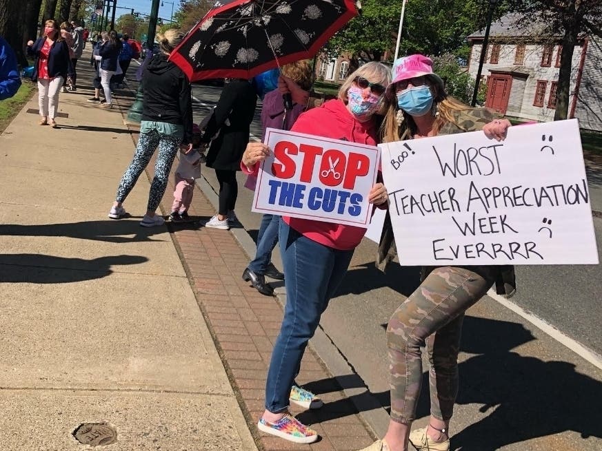 A protest outside Braintree Town Hall Thursday over school budget cuts drew over 100 people, including Braintree Integrated Preschool teacher Kristina Lutz and Braintree grandparent Andrea Pagnani.
