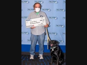 Leonard Thomas claimed his prize at the Mass Lottery headquarters in Dorchester, accompanied by his dog Mariah. He said he will use the winnings to buy a small house or year-round cottage.
