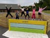 Girl Scouts in Brookline Troop 61033 jump for joy at the completion of their gaga pit at Captain Samuel Douglas Academy, the upper elementary school in Brookline. (Courtesy photo)