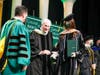 Alexis Dempsey is congratulated by her grandfather, Tom Dempsey, founder and CEO of Saddlebrook Resort Inc. in Wesley Chapel, and Saint Leo President Jeffrey Senese, upon receiving her Doctor of Business Administration degree on May 22. 