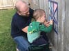Joe Lindbloom takes advantage of nice weather and helps his son create artwork on their fence.