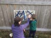 When the sun was out, so were the Lindbloom boys. Bridget guides her son in creating artwork on their fence.