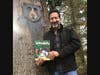 Barry Farber with a tree carving he did that was inspired by Bosco the Bear, one of the characters featured in The Adventures of Little Billy: In Search of the Magic Tree.
