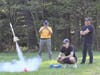 Cadet Captain Grayson Logan with Major Kent Hartig and Captain Antonio Fontes firing off a model rocket as part of Civil Air Patrol's STEM focused Model Rocketry Program.