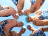 Team Caimans for a Cure from New Canaan, Connecticut, show off their fun swim day Swim Across America tattoos at the recent 19th annual Swim Across America - Fairfield County open water swim that raises funds for cancer research.