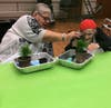 Evelyn Kornreich helps fellow resident Doris Brent transplant her plant