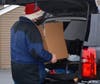 Ken loading a Christmas Basket into a recipient's vehicle