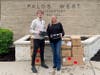 Palos West Elementary Principal Jennifer Peloquin receives a donation of shoes from Bradley Tritt, manager of the Orland Park Tradehome Shoes store.