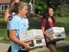 Rowers Maddie Dempsey and Rachel Coppinger assist with the book-moving effort
