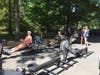 Rachel Coppinger, Stella Perdikis, and Morgan de Groot work out on the sliding ergs