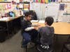 Nathan Wells, second-grader at Grand Prairie, talks with his third-grade buddy at Chelsea.