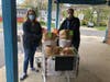 SOS Director Christie Winters and Brick Rotary Incoming President Jody Huss wheeling carts to cars for delivery