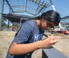 Girl signs steel beam before raising.