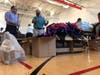 Halliburton employees talk strategy for sorting school supplies to fill backpacks with for Houston children.