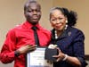 Southland CEO Dr. Blondean Y. Davis presents Southland junior Isaiah Adegoye with his Golden Apple award recognition for earning straight As.
