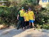 Josh Isaksen, Amber Isaksen, Ben Isaksen in front of a pile of gathered limbs