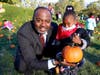 Matteson Village Trustee Andre Satchell helps Arcadia School kindergarten student Hazel Jackson choose her own pumpkin to take home. 