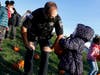Olympia Fields police officer Sean Barry admires a pumpkin chosen by a student at Arcadia School in Olympia Fields.