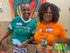 From left, Dr. Ann Jackson, founder and executive director of the Center for Food Equity in Medicine, and volunteer Pam Oliver stand among donations to be delivered to families challenged with life-altering or chronic disease such as cancer.