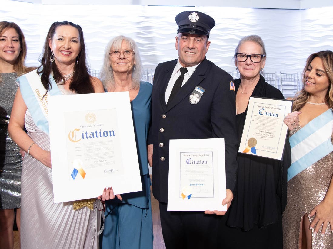 Pete Prudente, Firefighter of the Year, stands at center proudly displaying citations presented by Deputy Director of the Office of Minority Affairs Melissa Figueroa (far left) on behalf of elected officials. See photo caption five for more details.