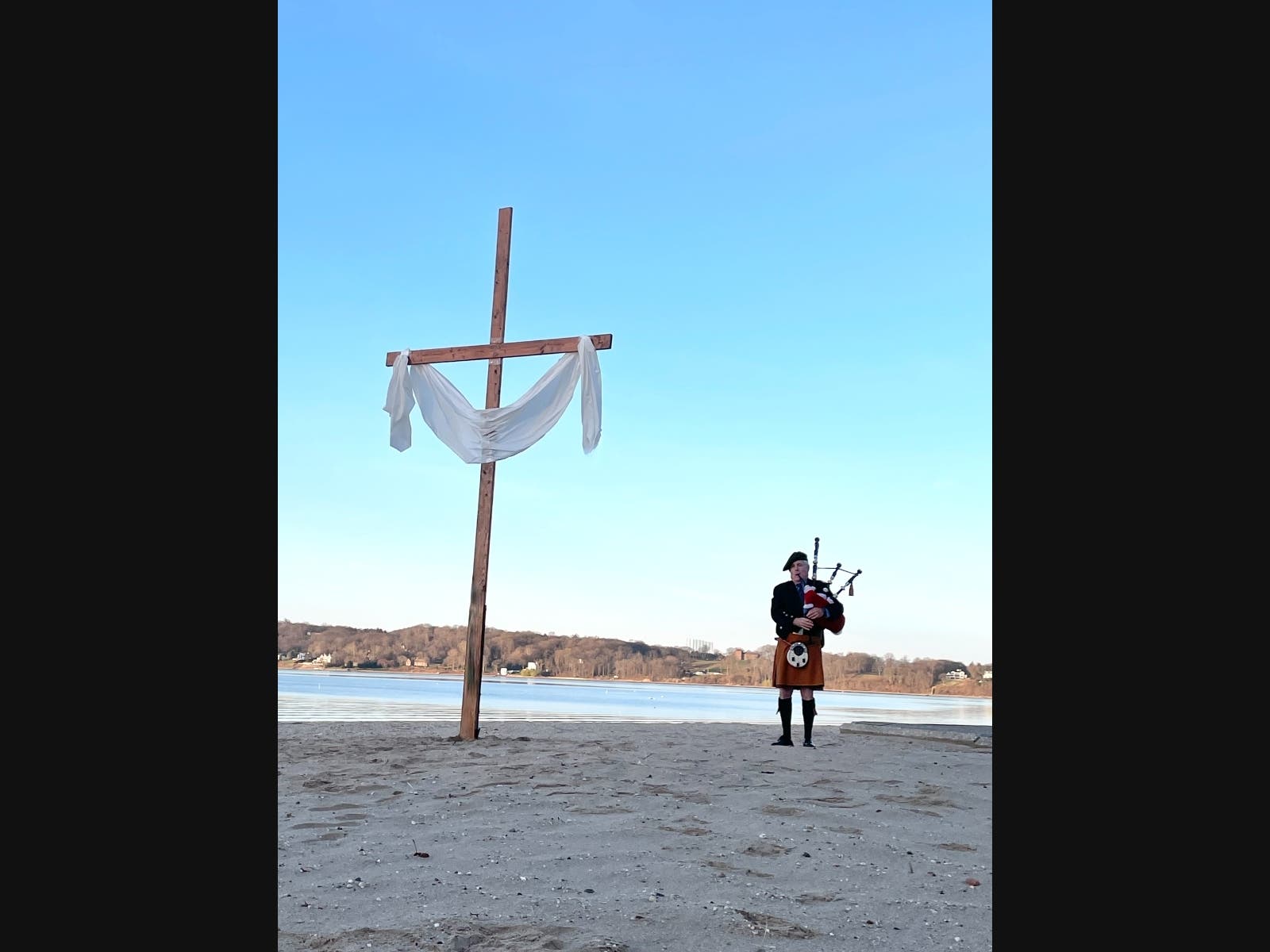 Bagpiper Robert Lynch opens the Annual Community Dawn Service with the playing of "Amazing Grace" at the foot of a 17’ cross that was installed earlier in the morning.