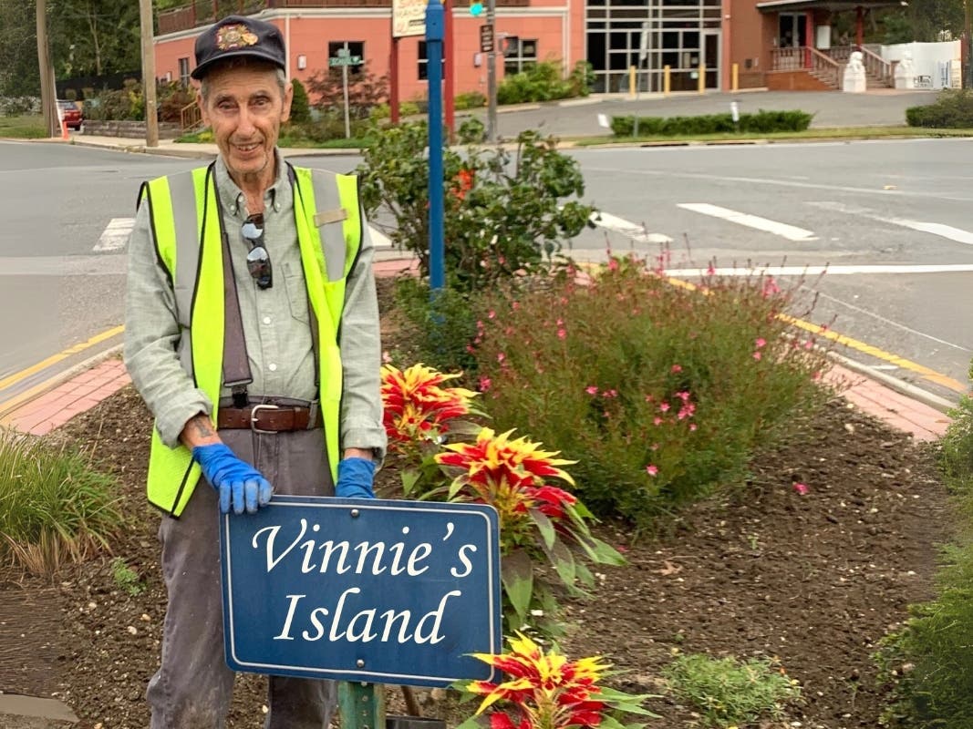 Vincent “Vinnie” Martinez Sr. stands proudly behind the sign marking Vinnie’s Island, his 40-year labor of love and dedication to the Glen Cove community.