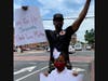 Supporter Kenny David and his daughter, Kenyana Davis hold up signs of support for BLM and show off rollerskating skills. 