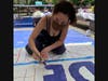 Margot Block paints Defend Black Lives Matter sign on BLM Plaza