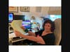Joyce holding a lists of emails that she sends out daily for her Zoom Zumba classes.