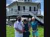 NZ Commodore David Gibbs, Paula Gibbs, and CBMM President Kristen Greenaway pose for a photo in front of Hooper Strait Lighthouse.