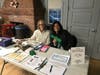 Society members Helen Enriquez, left, and Janelle Poulter, right, served as the meeting's greeters. 