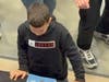 Young fan watches as Celtics Legends sign his basketball.