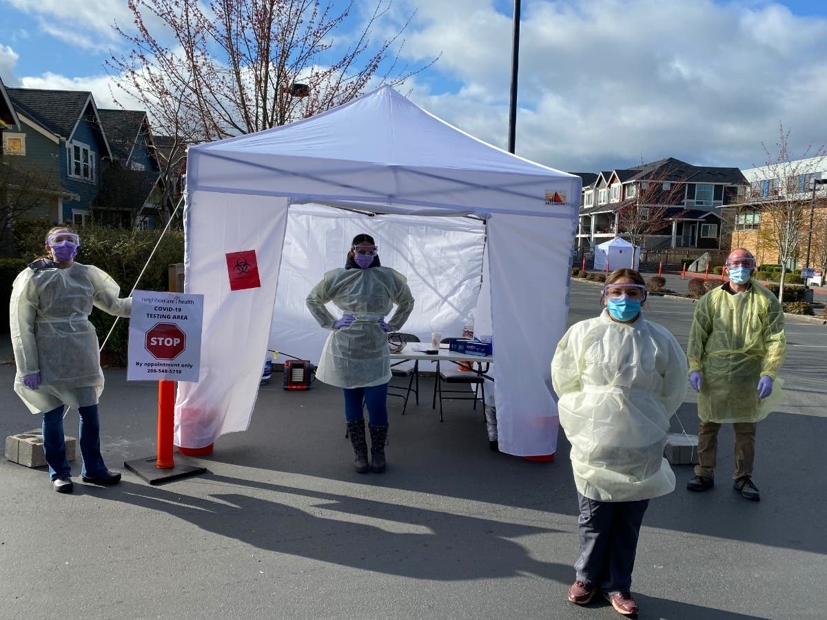 Neighborcare health care workers stand ready at its COVID-19 tent testing site in West Seattle
