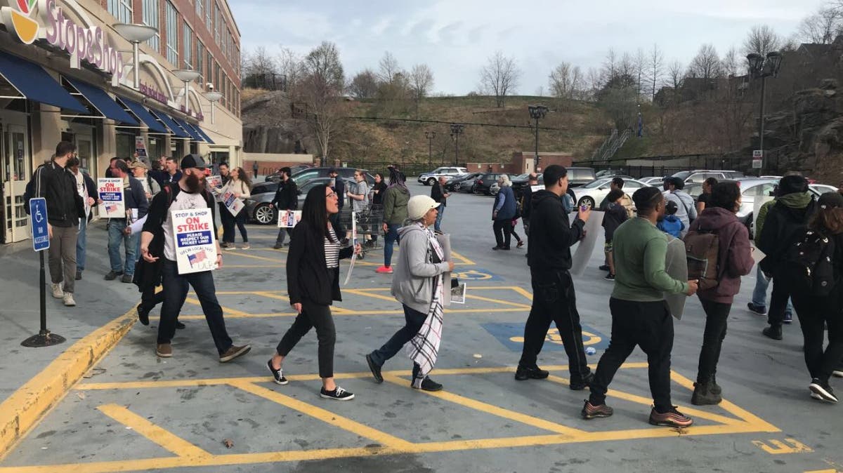 Strikers marched in a circle in the parking lot of the Mission Hill Stop & Shop.