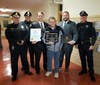 Chris Etre (center) poses alongside Grafton officers with his citation and plaque.