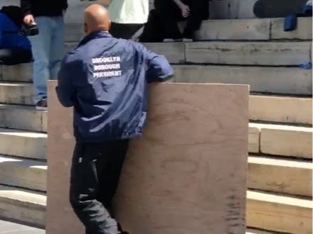 Borough President Eric Adams removes a skate ramp set up on the steps of Brooklyn Borough Hall.
