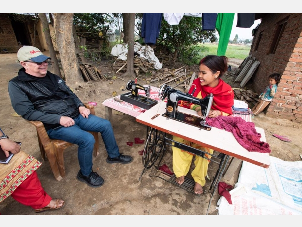 Maryknoll Father Joseph Thaler visits Reena Tharu, a graduate of the residential sewing program for disabled people in Nepal.