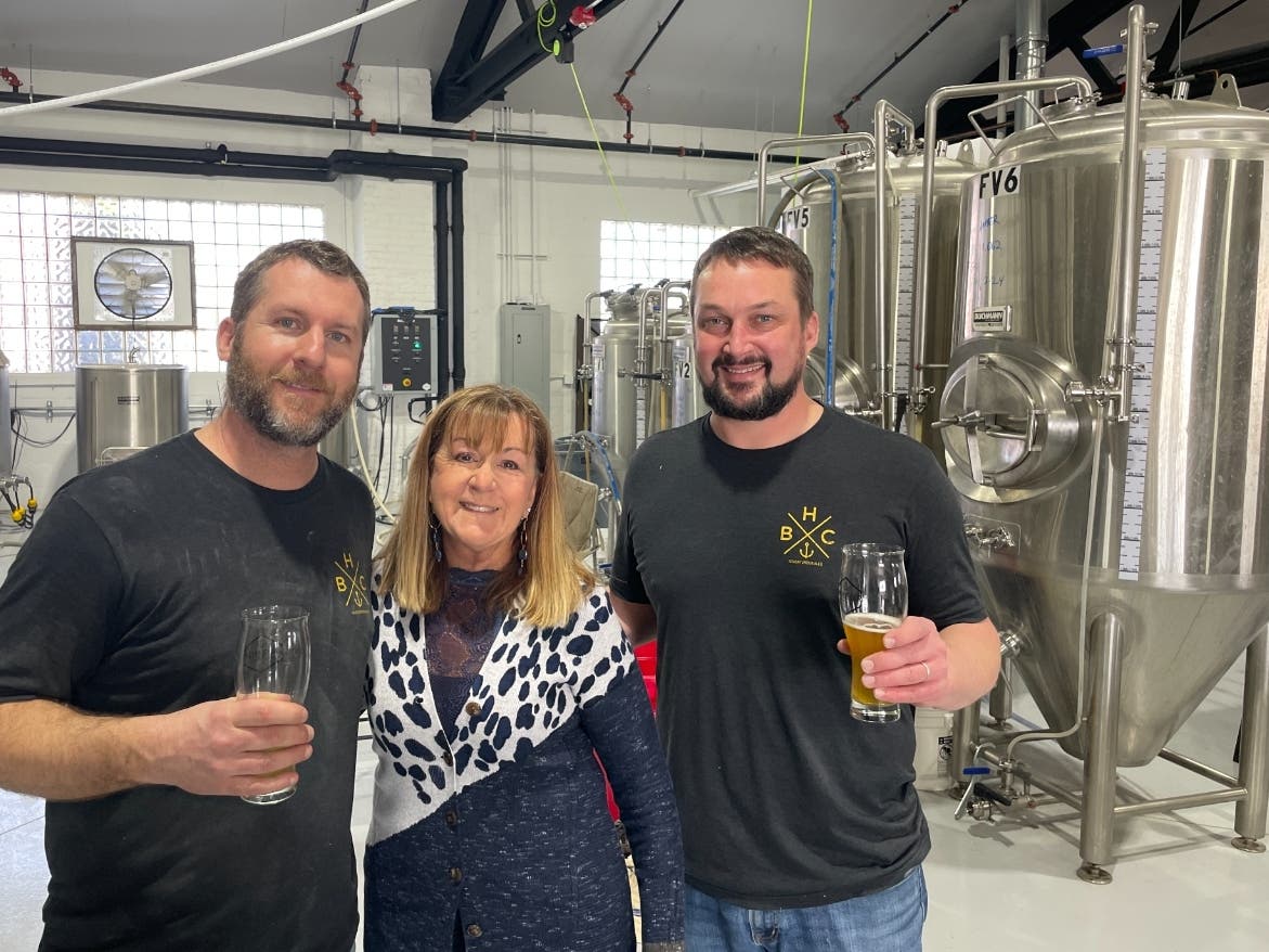 Jim Valsa (left) and Dave Auston of 9th Hour Brewing greet Wendy Richardson of Richardson Farm during a spring visit to the Lake Villa brewery, one of several offering samplings at the Craft Beer Adventure Festival at the farm June 25.

