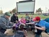 Shown (clockwise from bottom) are Rylee Espinosa, Karl Plancon, Steven, Taylor and Levi Espinosa and Rachel, Danika and Donovan Plancon playing Uno before the start of the double feature Saturday, May 9, at the McHenry Outdoor Theater.