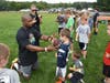 Former NFL Running Back, Ahman Green, gives training on the proper technique to hold a football to Sudbury's Ben Connelly at Red Zone's Train Like a Pro Skills Clinic.