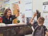Bilingual Clerk Lupita Garcia high fives a student on his way to class at Central Elementary School on opening day. 