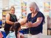 Kindergarten student Melanie Gutierrez gets warm welcomes from her teacher Jan Carson and kindergarten aide Josie Foster during the first day of classes at Central Elementary School. 